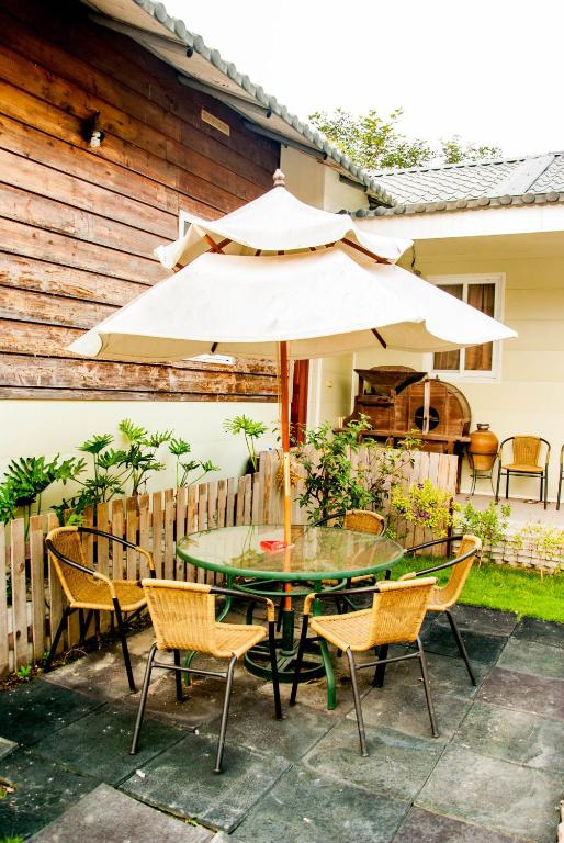 a table and chairs with an umbrella on a patio at Song Youf Hostel in Zhongpu