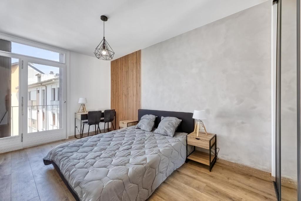 a bedroom with a large bed and a large window at La Boisée in Annemasse