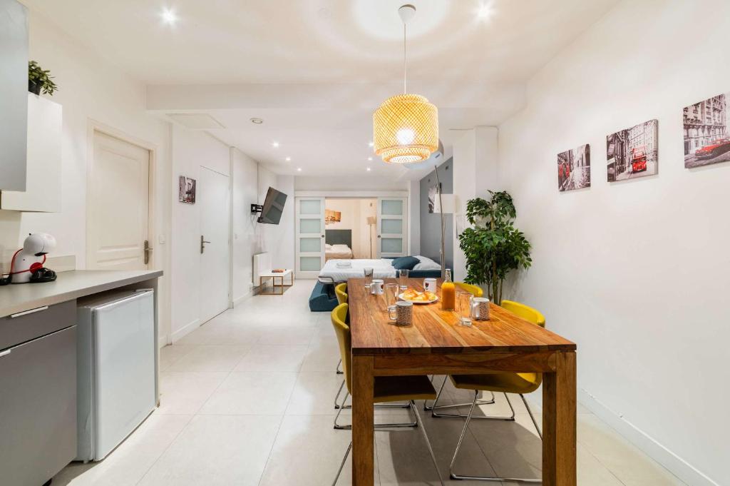 - une cuisine et une salle à manger avec une table en bois dans l'établissement Loft moderne face jardin des plantes - 4P, à Paris