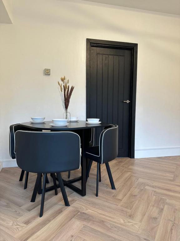 a black dining room table with chairs and a black door at 2 Bedroom flat by London Bridge & The Shard in London