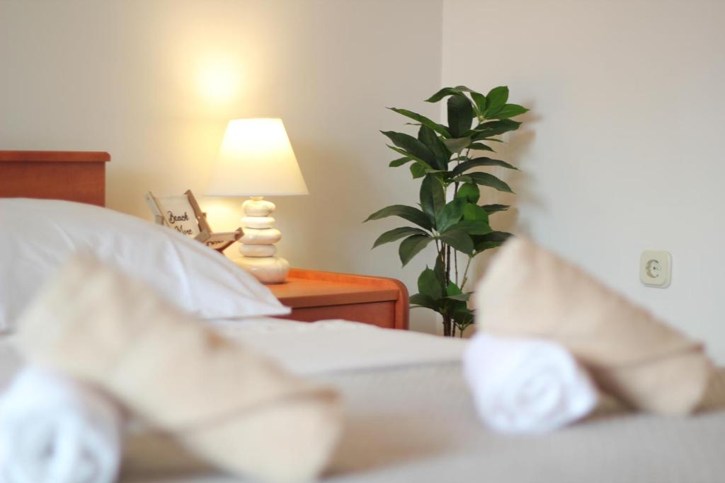 a bedroom with a bed with a lamp and a plant at Dolce Mare Apartmani in Pakoštane