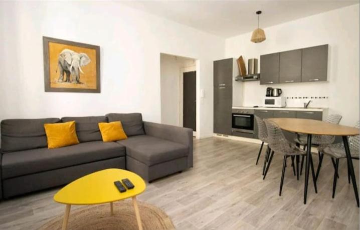 un salon avec un canapé et une table et une cuisine dans l'établissement Charming T2 - heart city center, à Marseille