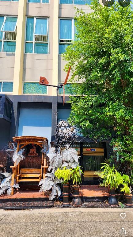 a wooden bench in front of a building at Modicoff Hotel in Sathani Ban Chim Phali