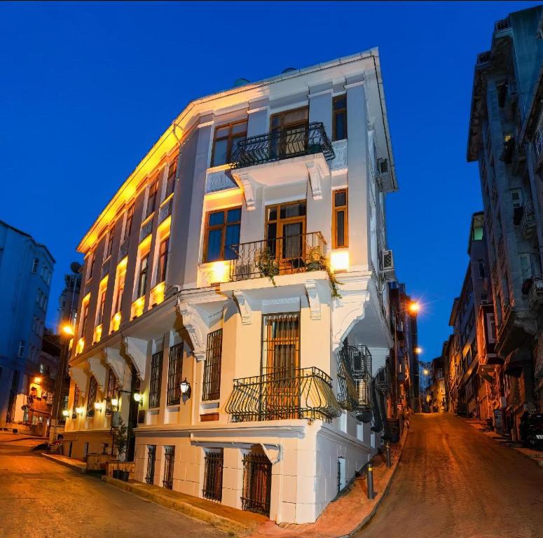 a white building on a city street at night at 1826 Heritage Rooms in Taksim
