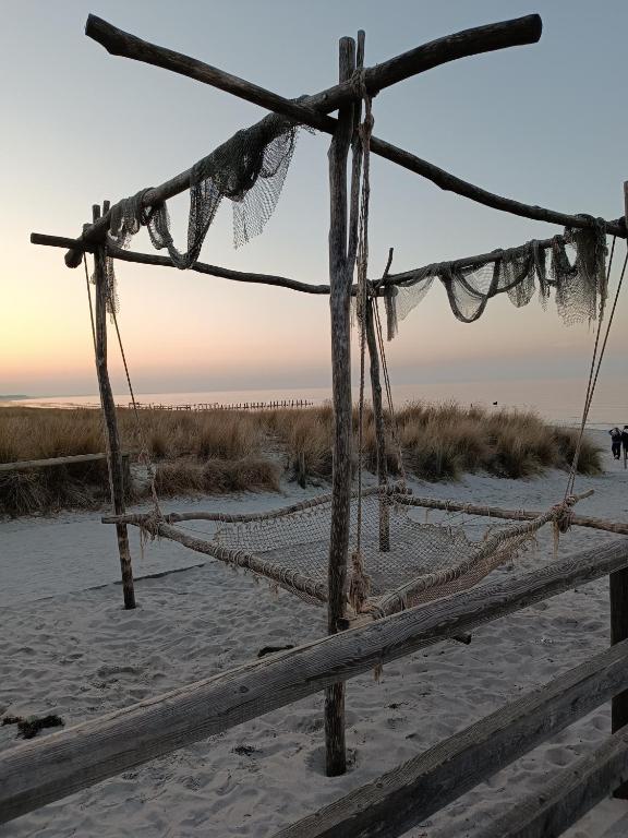 a wooden fence on the beach with the ocean in the background at Ostseemeerchen in Zingst