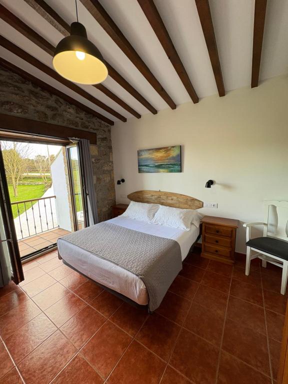 Un dormitorio con una cama y una ventana grande. en Posada Punta Liñera, en San Vicente de la Barquera