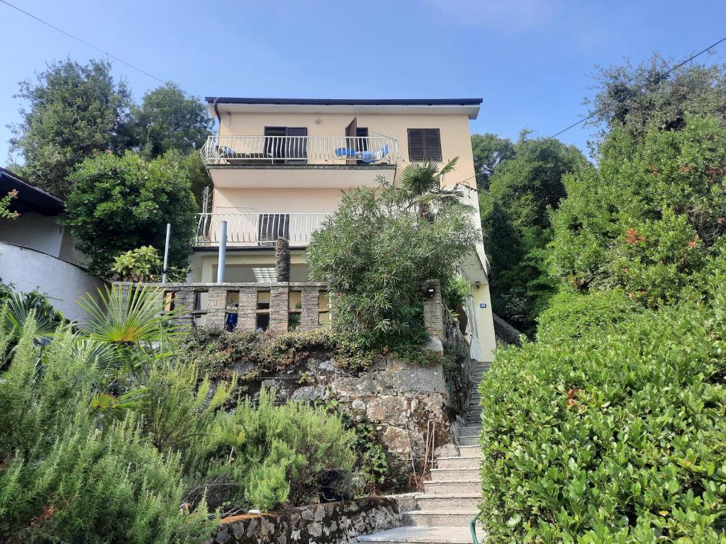a house with a staircase leading up to a building at Rooms Vid&Rok in Mošćenička Draga