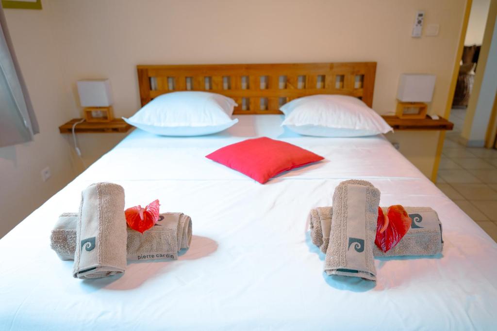 a large white bed with towels on top of it at Anse Caraïbes Appartement in Les Trois-Îlets