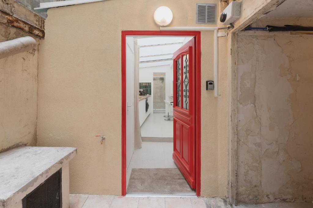 une porte rouge menant à une cuisine dans une maison dans l'établissement Mini Loft Buttes Chaumont, à Paris