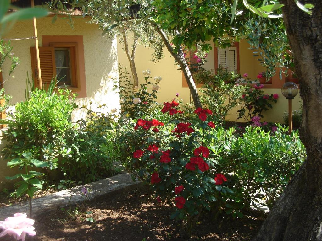 um jardim em frente a uma casa com flores vermelhas em Residence Giardino em Vieste