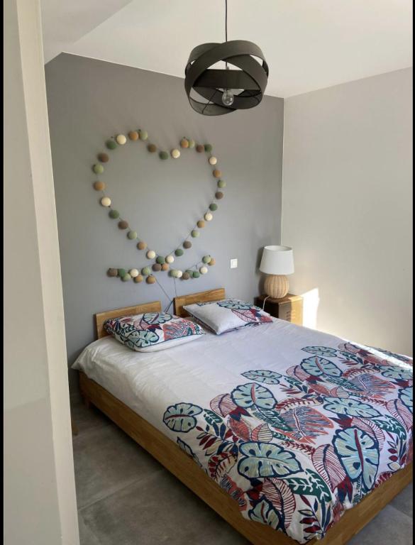 une chambre avec un lit avec un cœur sur le mur dans l'établissement Beautiful home for 2-8 people with a pool, à Roquefort-la-Bédoule