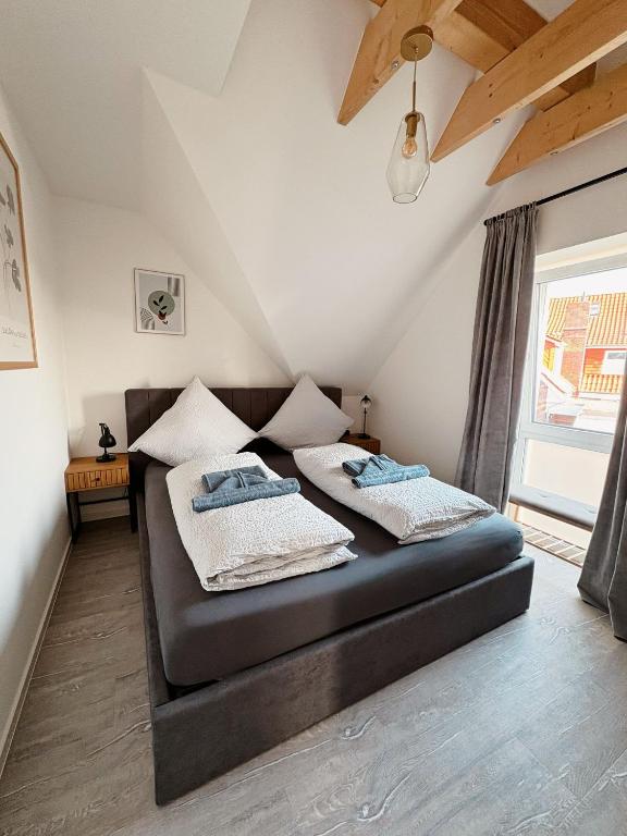 two beds in a room with a attic at Ferienwohnung KÖÖK Küstentraum - Modern, Balkon, Strandnah, Maisonette in Neuharlingersiel