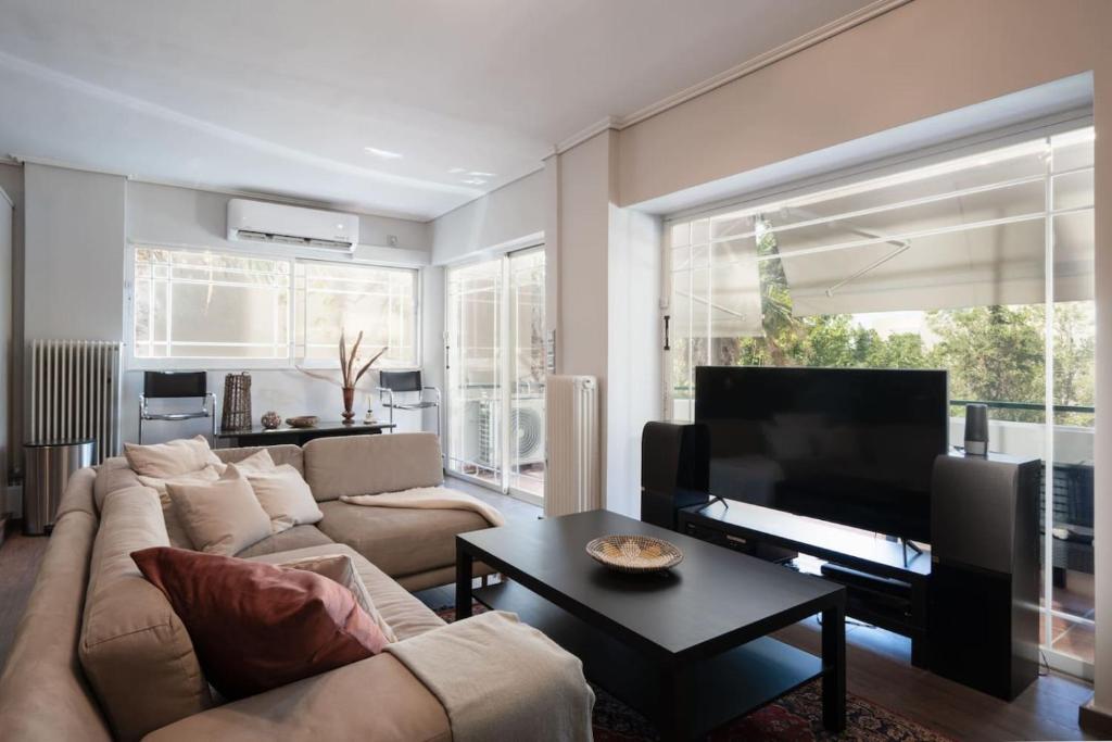 a living room with a couch and a flat screen tv at Luxe Bliss 2BR, Glyfada in Athens