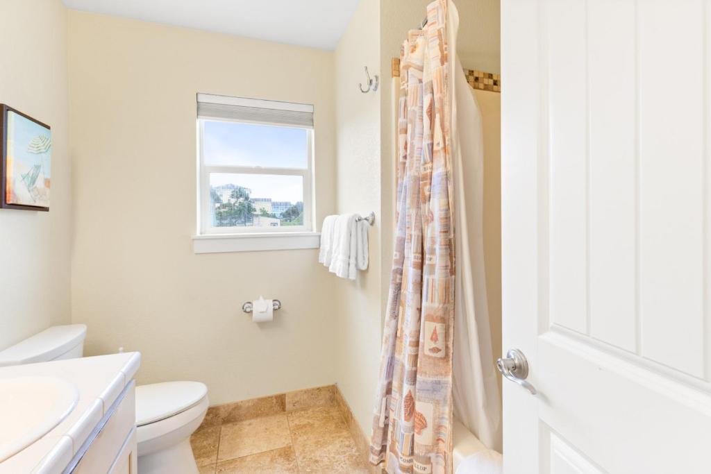 a white bathroom with a toilet and a shower at Blue Marlin, Arcade, Hot Tub, Sleeps 10 in Lincoln City