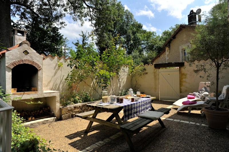 a patio with a table and a pizza oven at Moulin De Larcy in Ribérac