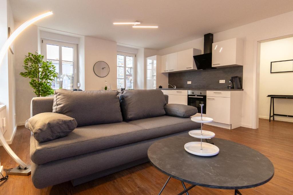 a living room with a couch and a table at Fewomo - Moseltraum ! Exklusive Unterkunft für Genießer - Nah am Schloss in Lieser