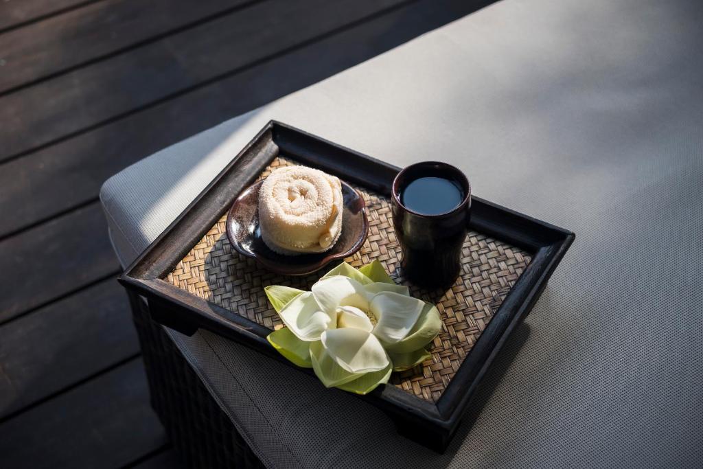 a tray with a drink and a pastry on a bed at Anantara Peace Haven Tangalle Resort in Tangalle