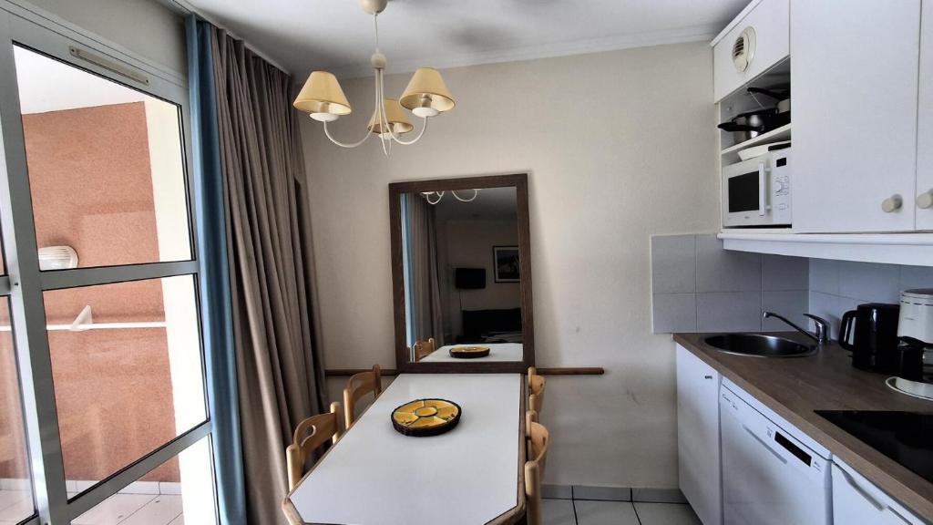 une cuisine avec une table avec un bol dessus dans l'établissement Résidence le Hameau de Cap Esterel - maeva Home - Appartement 2 Pièces 5 Personnes - Sélection MAE-9687, à Saint-Raphaël