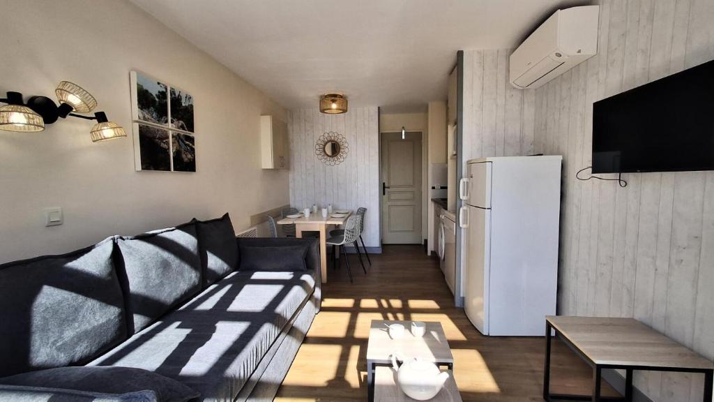 - un salon avec un canapé et un réfrigérateur dans l'établissement Résidence le Village de Cap Esterel - maeva Home - Appartement 2 pièces 6 personnes - Prestige MAE-4121, à Saint-Raphaël