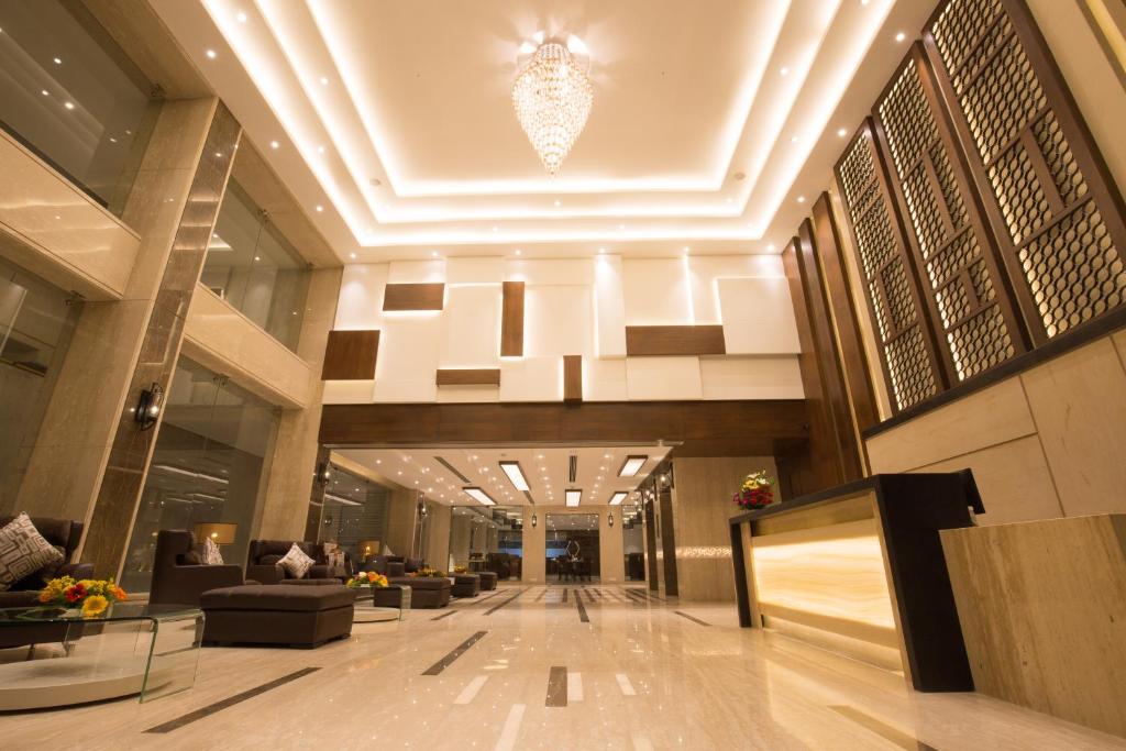 a lobby of a building with couches and a chandelier at Kiscol Grands Hotel in Coimbatore