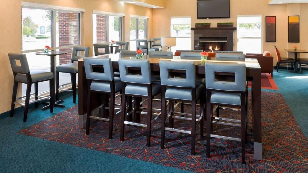 a conference room with a bar with chairs and a fireplace at MainStay Suites Appleton Airport - Fox River Mall Area in Appleton