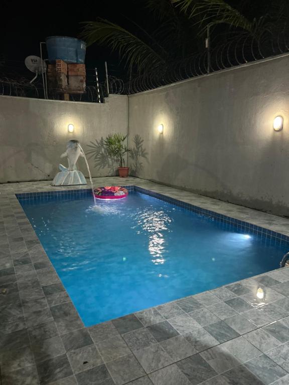 a swimming pool at night with a water fountain at Paraíso no Chapéu Virado in Belém