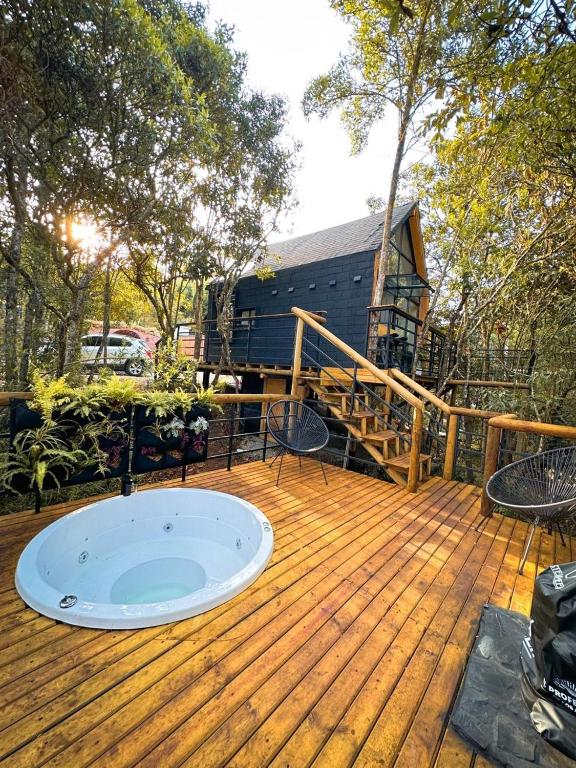 a hot tub on a wooden deck with a house at Cabaña Lambrusco - La Cava Lodge in Medellín