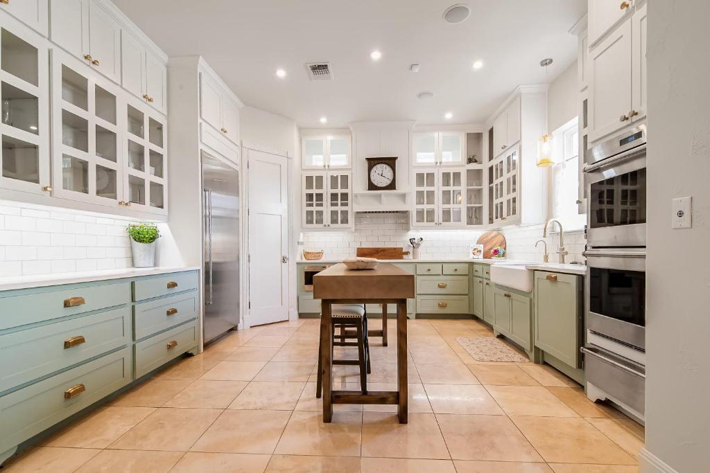 une cuisine avec des armoires blanches et une table à l'intérieur dans l'établissement King Beds Hot Tub On 290 Large Estate Kitchen, à Fredericksburg