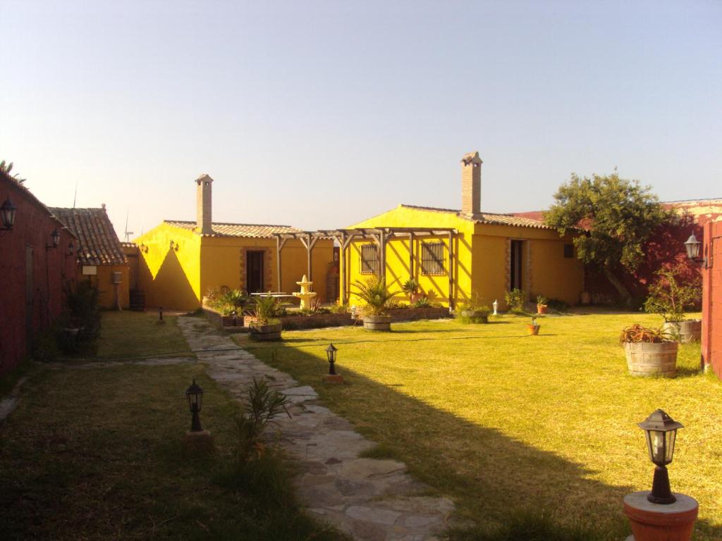 ファシナスにあるApartamentos Daperの前方の芝生の黄色い家