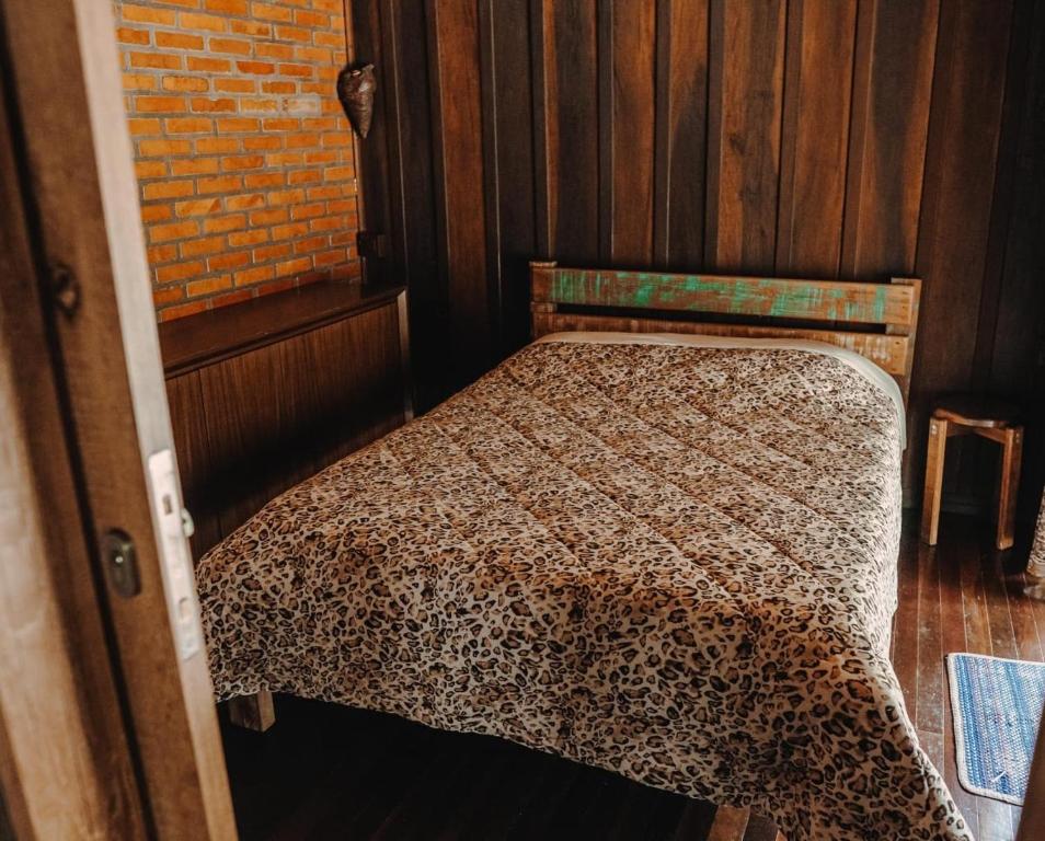 - une chambre dotée d'un lit avec une couverture à motifs léopards dans l'établissement Chalé Sanga, à Jaraguá do Sul