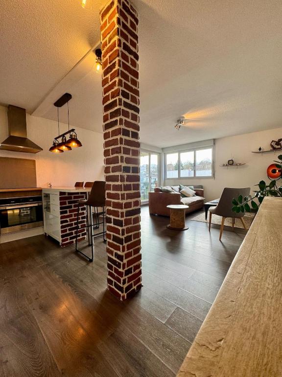 - un salon avec un pilier en briques au milieu dans l'établissement Le Toulousain T3 Parking Calme, à Toulouse