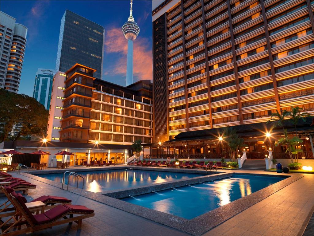 a large swimming pool in a city with buildings at Concorde Hotel Kuala Lumpur in Kuala Lumpur