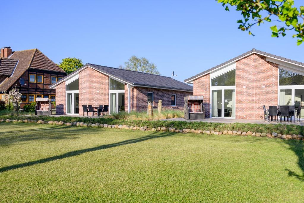 une maison avec une pelouse devant dans l'établissement Ferienhaus Hofkiek - Bauernhof Hopp Vadersdorf, à Fehmarn