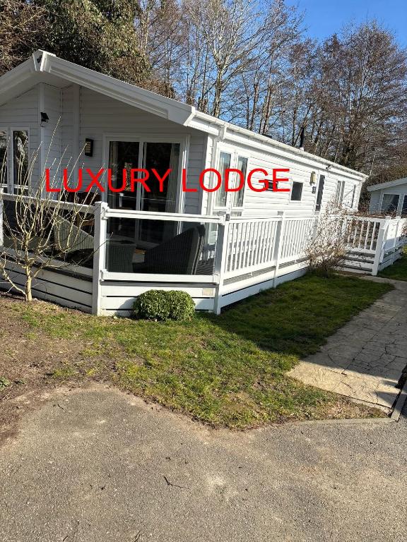 a white house with a luxury lodge sign on it at Luxury lodge T11 in Hastings