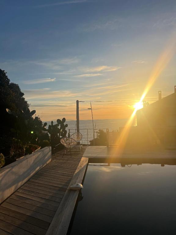 - une piscine avec un coucher de soleil sur l'océan dans l'établissement Haut de villa avec piscine au bord de mer, à San-Martino-di-Lota