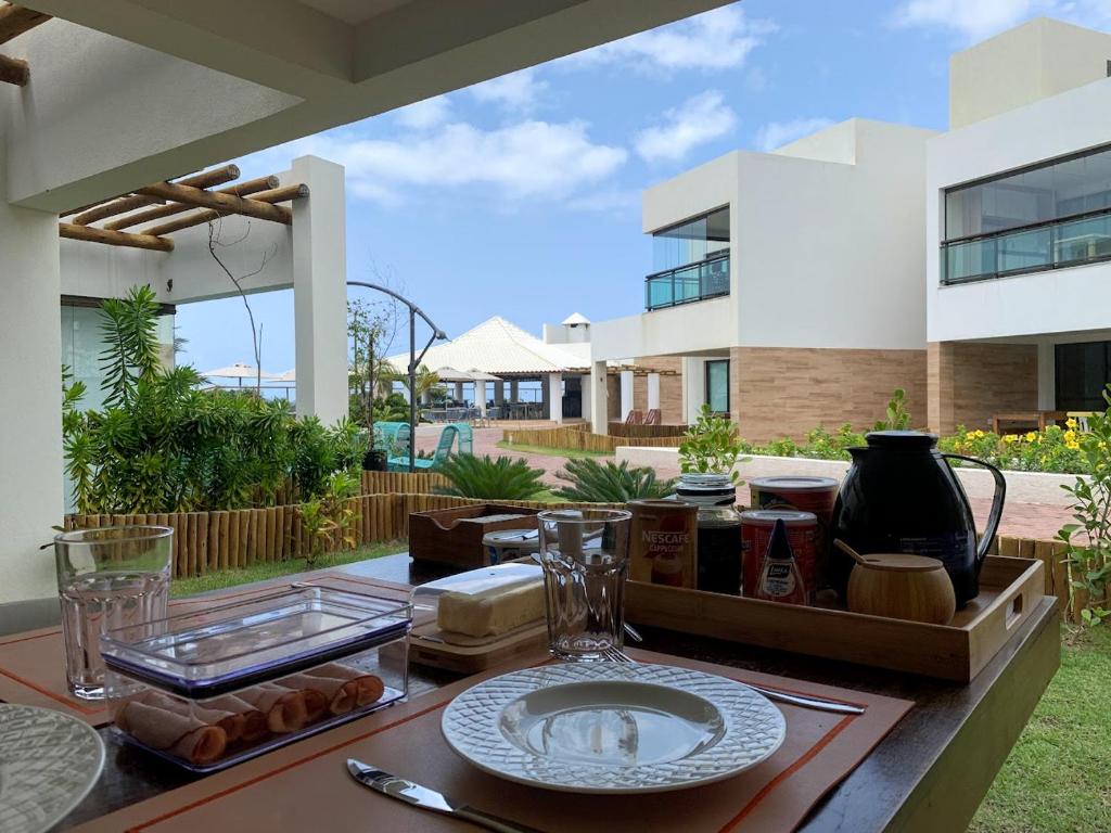 a table with a plate of food on a patio at Itacimirim Beach Unique in Camacari