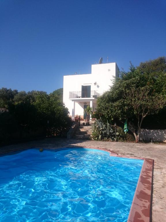 a swimming pool in front of a white house at Monteviccoli in Ceglie Messapica