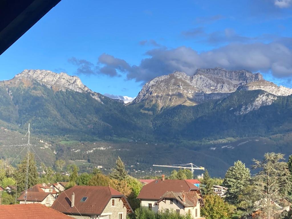 une vue d'une chaîne de montagnes avec des maisons et des montagnes dans l'établissement appartement la tournette, à Saint-Jorioz