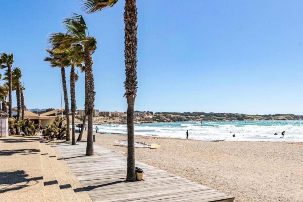 une plage de sable avec des palmiers et l'océan dans l'établissement Résidence Bastide - Magnifique maison a 200m de la mer avec piscine privée spa et terrain de pétanque MAE-5901, à Six-Fours-les-Plages