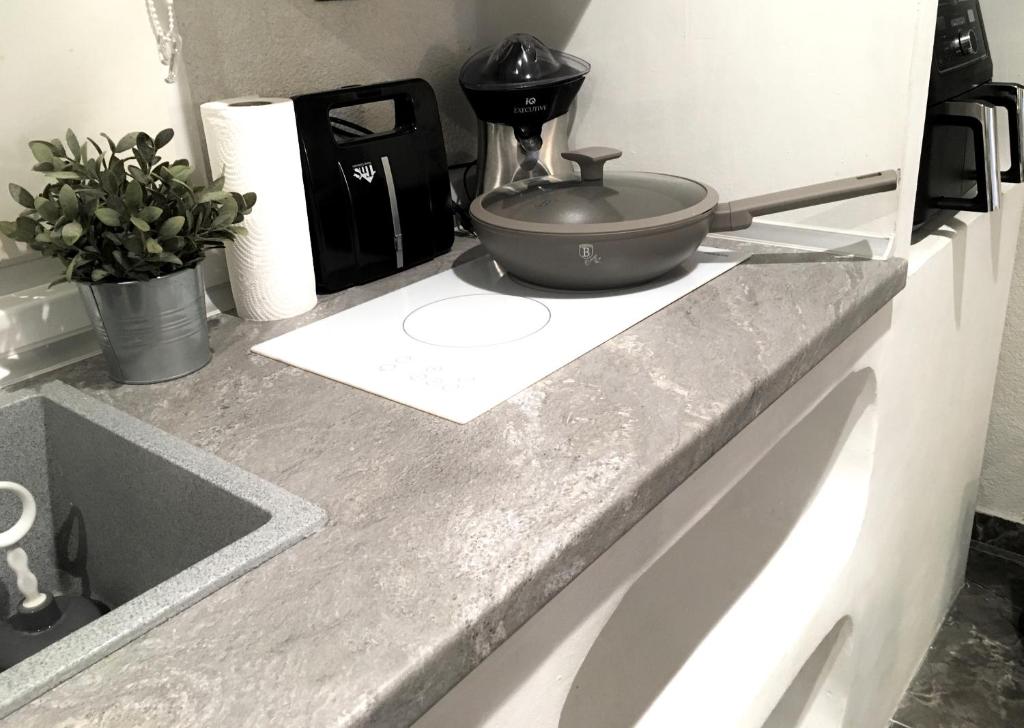 a counter top with a pot and a bowl on it at Cycladic Suite in Thessaloniki
