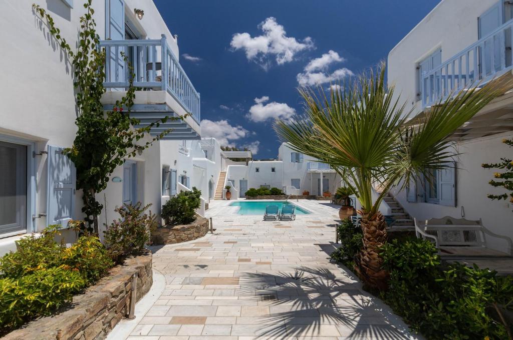 a courtyard of a villa with a swimming pool at Mimosa Retreat Mykonos in Ornos