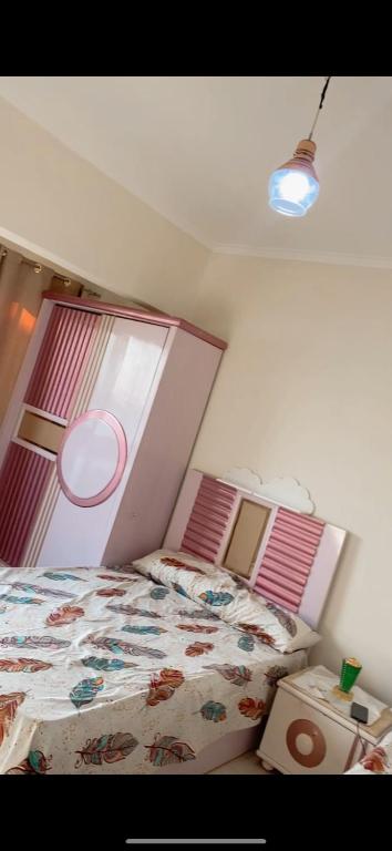 a bedroom with a bed with a pink head board at المعادي in Cairo