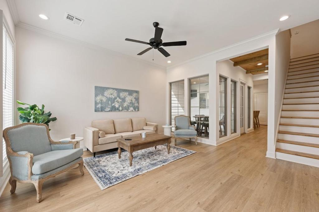 ein Wohnzimmer mit einem Deckenventilator und Stühlen in der Unterkunft NEW Lafayette House KING Beds Garage Patio Luxury in Lafayette