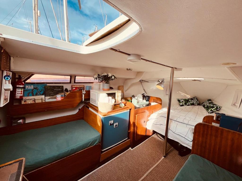 a room with a bed and a desk in a boat at Bacus - Your Floating Hideaway in Lisbon in Lisbon
