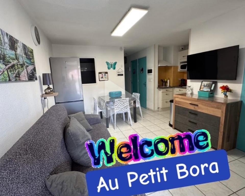 un salon avec un canapé et une cuisine dans l'établissement Le Petit Bora-Marseillan Plage -Residence Bora Bora-400m plage d'honneur, à Marseillan