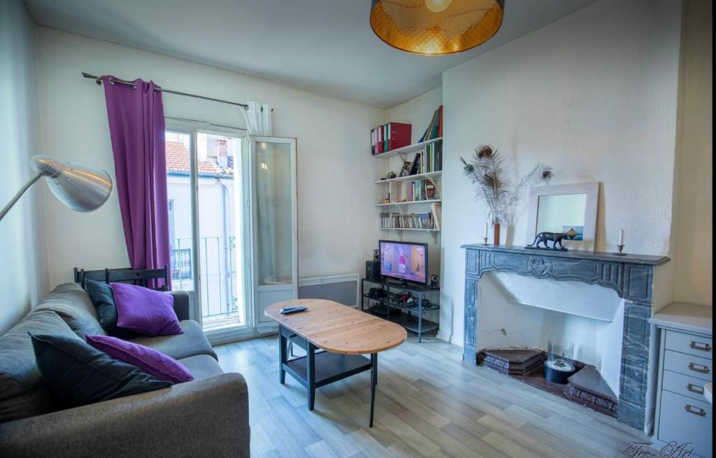 un salon avec un canapé et une table dans l'établissement Le Farges-St Roch-2 chambres-LaConciergerieByNina, à Montpellier