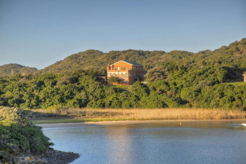 a house on top of a hill next to a river at Mgwalana River Lodge in Mgwalana Mouth