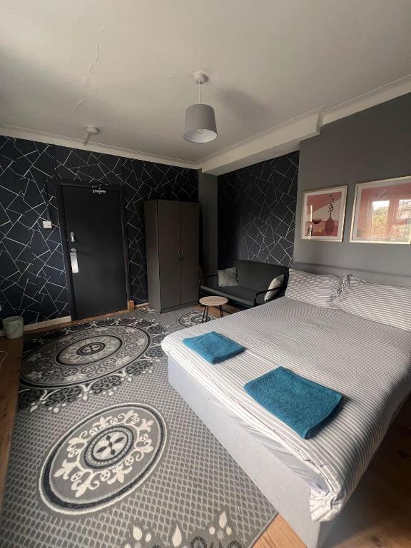 a bedroom with a large bed with blue towels on it at Colebert Avenue in London