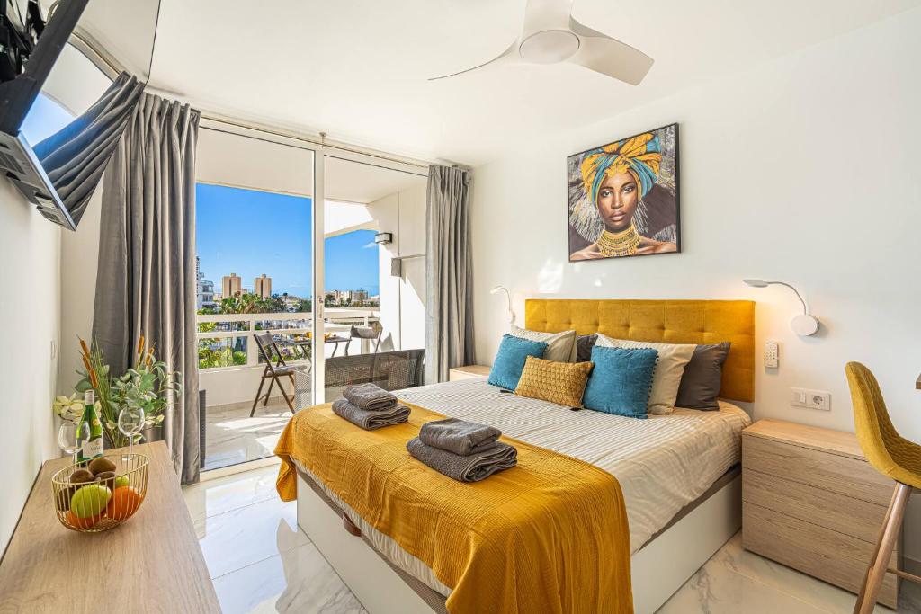 a bedroom with a bed and a large window at GOLDEN VIEW Ponderosa in Costa de Adeje