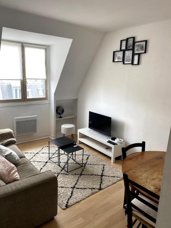 un salon avec un canapé et une table dans l'établissement Cozy 2-Room Flat at Boucicaut, à Paris